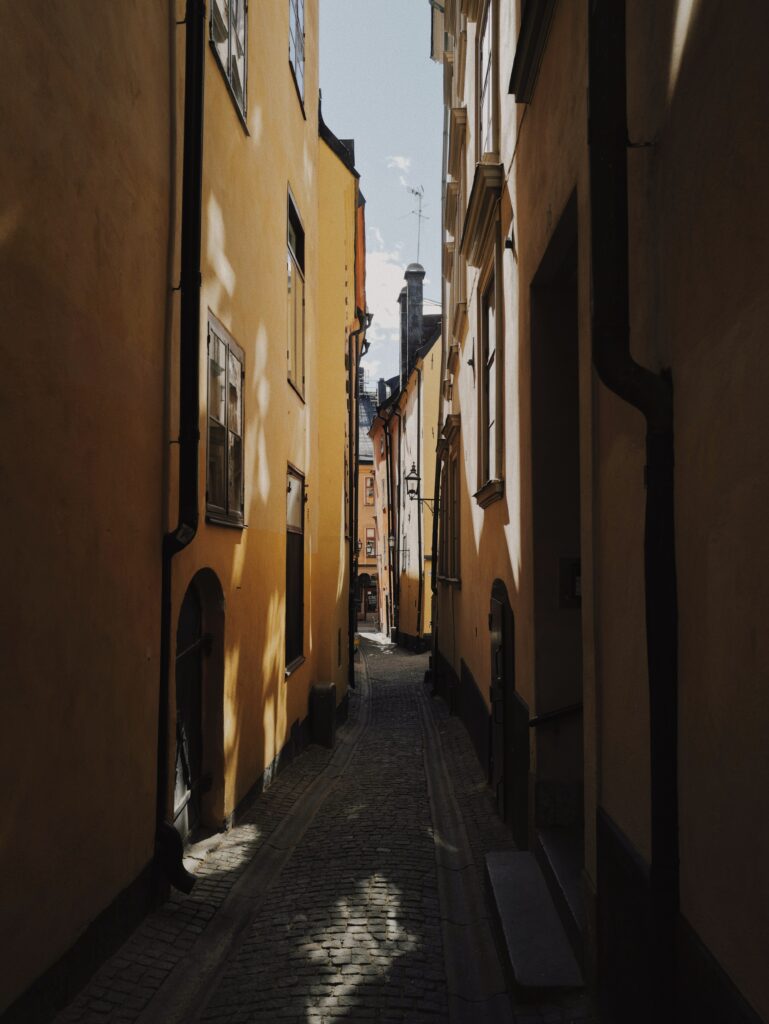 Serene Cobblestone Street: Charming Yellow Buildings & Tranquil Atmosphere Wallpaper