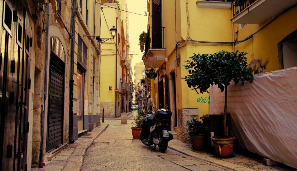 Charming Cobblestone Street with Rustic Buildings & Modern Motorcycle Wallpaper