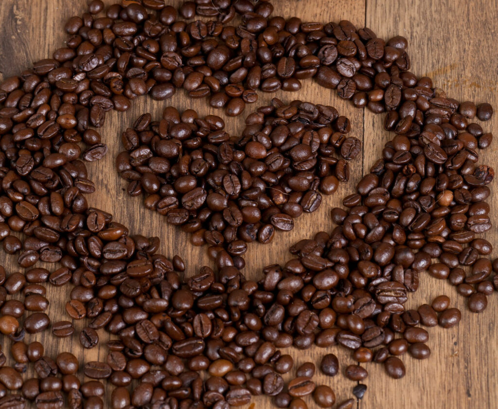 Charming Dark Roast Coffee Beans Heart Wallpaper on Rustic Wood