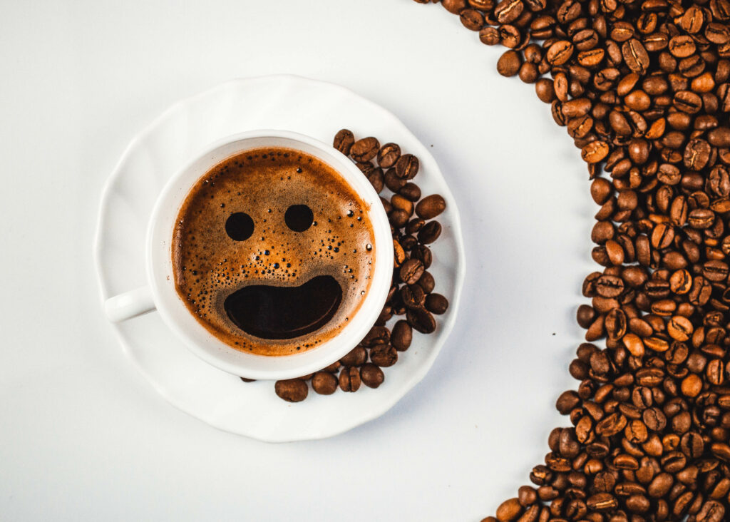 Charming Coffee Wallpaper: Smiling Foam & Coffee Grains on White