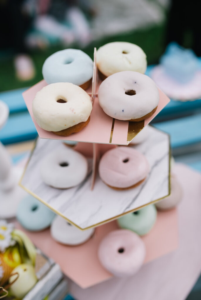 Charming Dessert Wallpaper: Tiered Stand of Pastel Frosted Donuts
