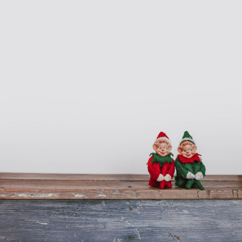Charming Elf Dolls on Wooden Bench - Whimsical Minimalist Wallpaper