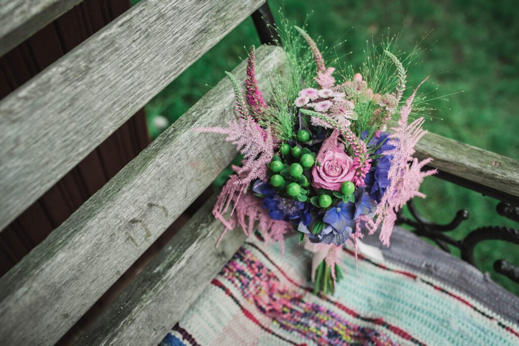Charming Floral Wallpaper: Vibrant Bouquet on Rustic Wooden Bench