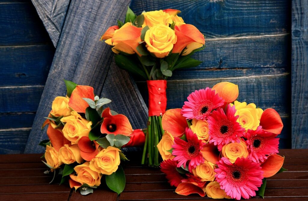 Vibrant Floral Bouquets on Rustic Blue Wooden Table - Charming Background Wallpaper