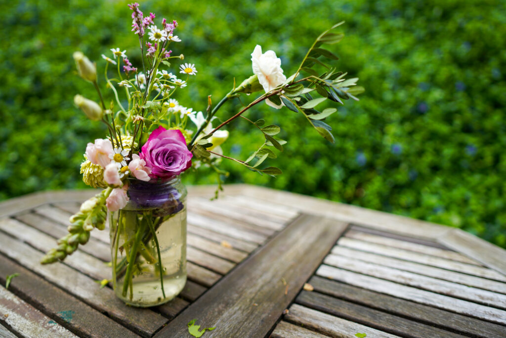 Charming Flower Bouquet in Rustic Jar on Wooden Table - Nature Aesthetic Wallpaper