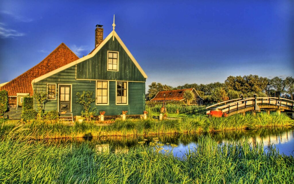 Charming Green House Wallpaper: Serene Canal & Rustic Bridge Scene