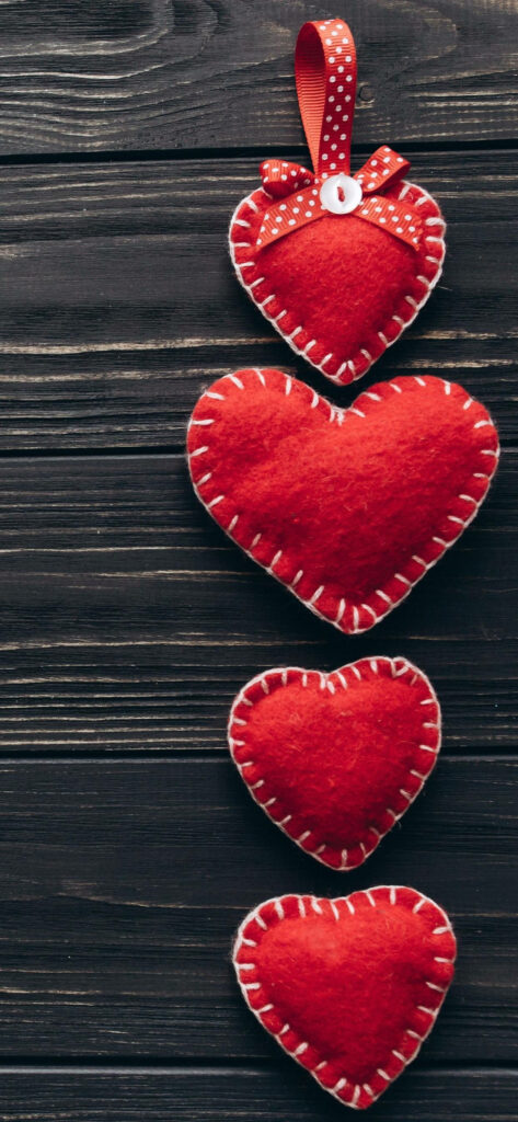Charming Red Fabric Hearts Wallpaper on Rustic Wood Background