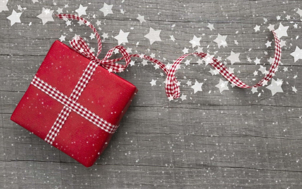 Festive Gift in Red Paper with Checkered Ribbon on Wood Background Wallpaper