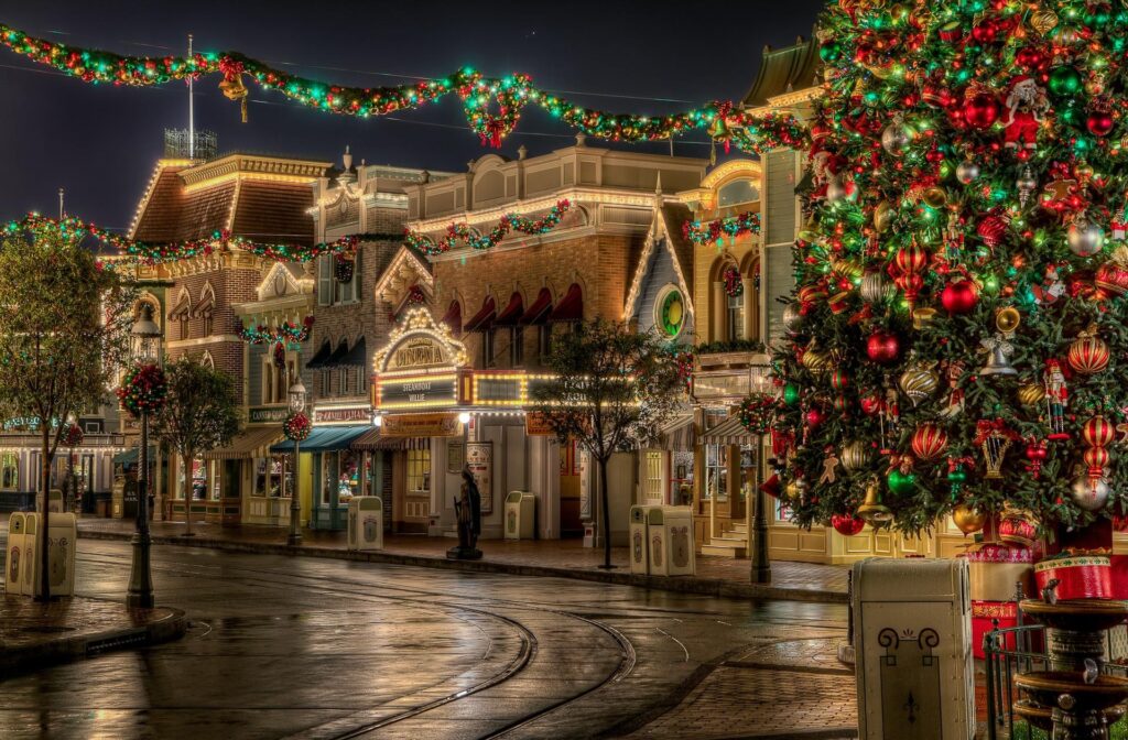 Charming Holiday Street Scene with Festive Lights and Christmas Tree Wallpaper
