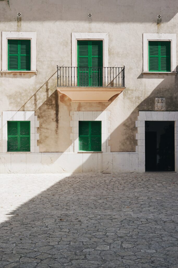 Charming Old Building Facade Wallpaper with Green Shutters & Balcony