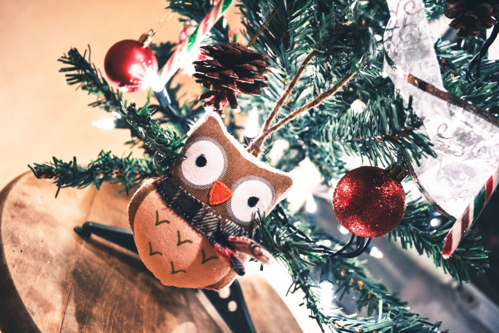 Cozy Christmas Wallpaper: Owl Plush Toy Among Decorated Tree