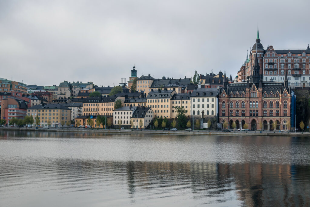 Serene Riverside View: Charming Historic Architecture Wallpaper