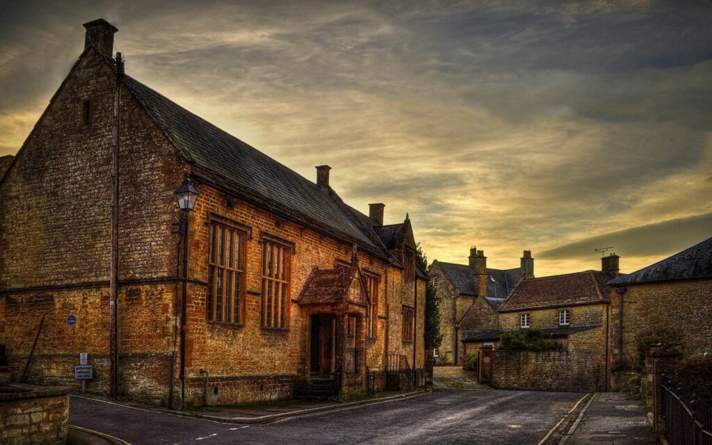 Serene Rustic Street Scene Wallpaper: Cozy Homes & Warm Sunset Light