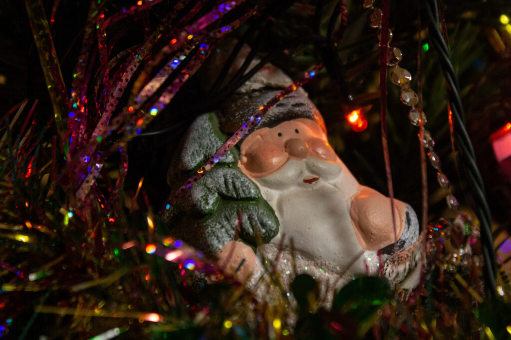 Charming Santa Ornament Amidst Festive Christmas Tree Decorations Wallpaper
