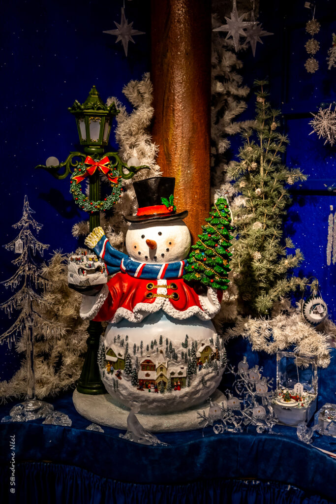 Charming Snowman Wallpaper: Holiday Cheer & Winter Village Scene