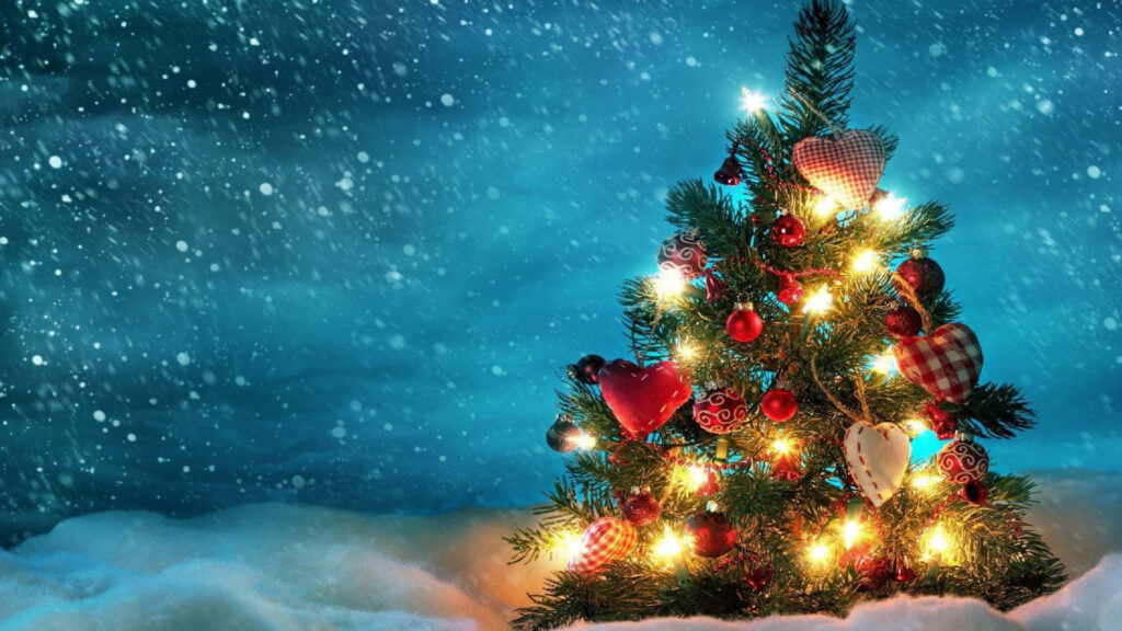 Magical Christmas Tree in Snowy Landscape with Heart Ornaments Wallpaper