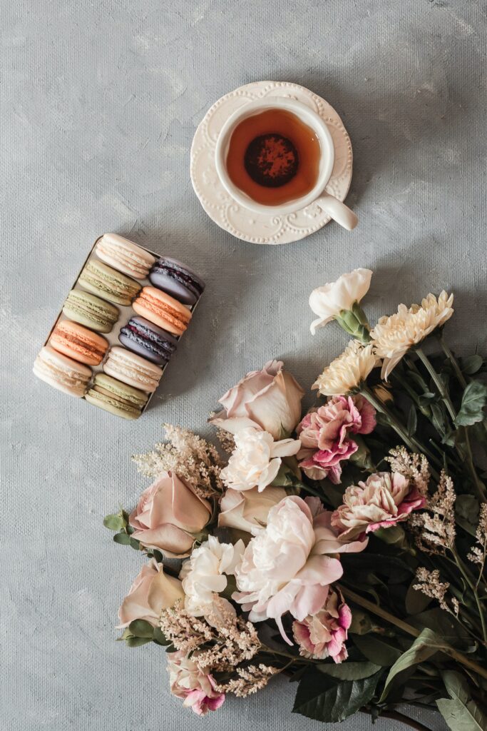 Charming Tea Cup Wallpaper with Macarons, Cookies, & Floral Beauty