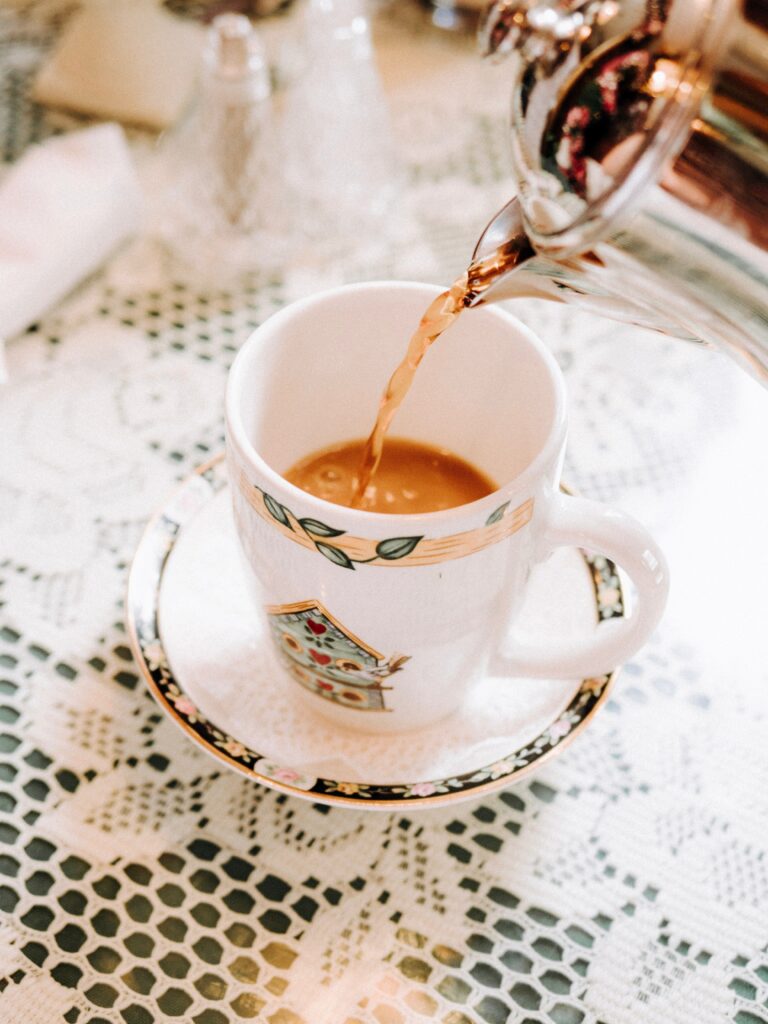 Cozy Tea Party Scene: Elegant Cup on Lace Tablecloth Wallpaper