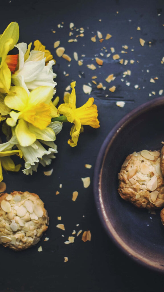 Almond Cookie Wallpaper: Sliced Almonds & Daffodils on Dark Background
