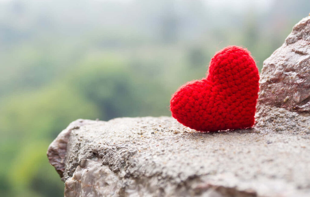 Bright Red Knitted Heart Wallpaper on Rocky Surface - Love & Nature