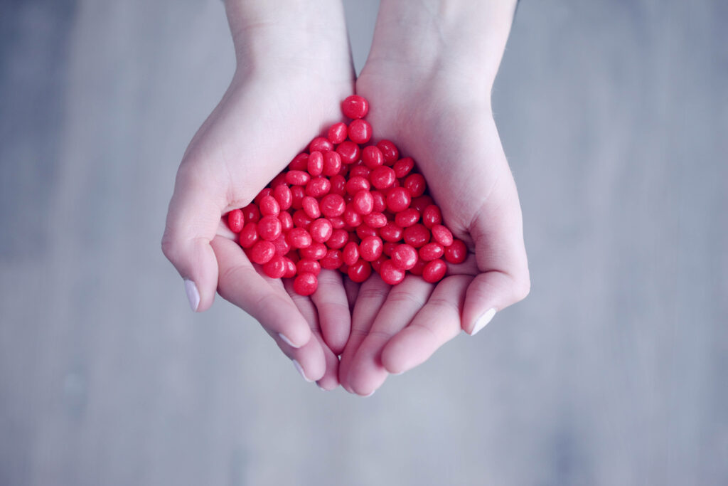 Charming Wallpaper: Cupped Hands Holding Vibrant Red Candies