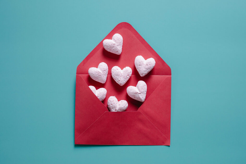 Cheerful Vibrant Red Envelope with Pink Hearts Wallpaper Background