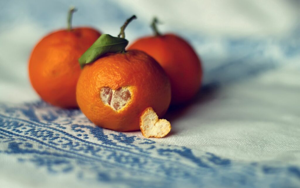 Artistic Tangerine Wallpaper: Vibrant Citrus on Delicate Fabric