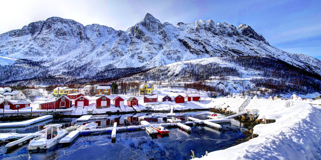 Scenic Winter Wallpaper: Norway's Snowy Mountains & Colorful Bay