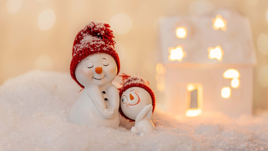 Charming Winter Scene: Cheerful Snowmen in Cozy Snowy Landscape Wallpaper