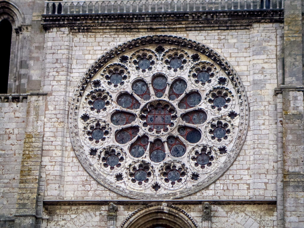 Intricate rose window of Chartres Cathedral with Gothic stonework and stained glass wallpaper background