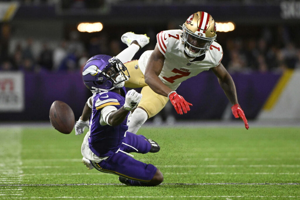 Charvarius Ward defends fiercely against Minnesota Vikings player in vibrant football action wallpaper