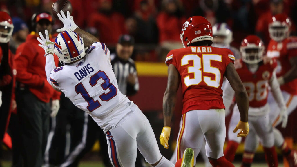 Charvarius Ward in red Chiefs uniform defending Buffalo Bills player Davis catching pass under lights Wallpaper