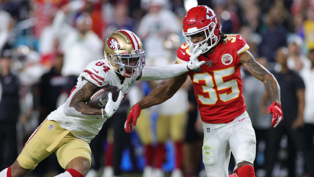Charvarius Ward intense NFL defensive play vibrant red gold team colors dynamic wallpaper background