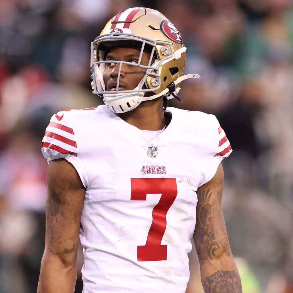 Charvarius Ward in white 49ers jersey number 7 focused on field with gold helmet background Wallpaper