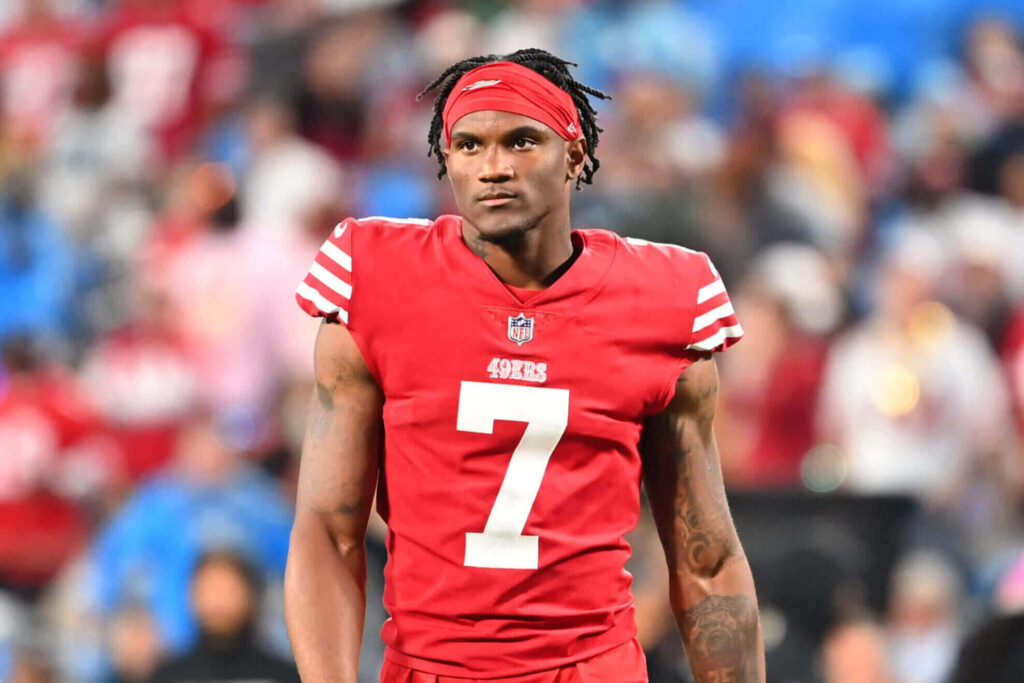 Charvarius Ward in red and white San Francisco 49ers uniform focused during intense game day Wallpaper
