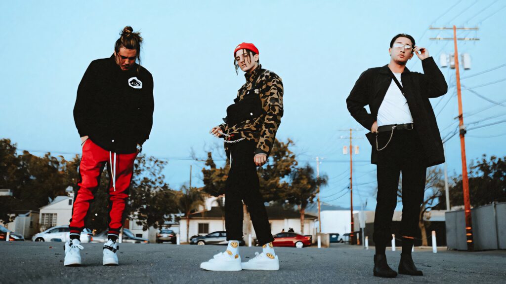 Chase Atlantic members in edgy street fashion on suburban street with bold patterns and cool tones Wallpaper