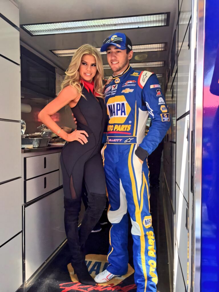 NASCAR driver Chase Elliott in blue NAPA racing suit with woman in black inside team trailer wallpaper