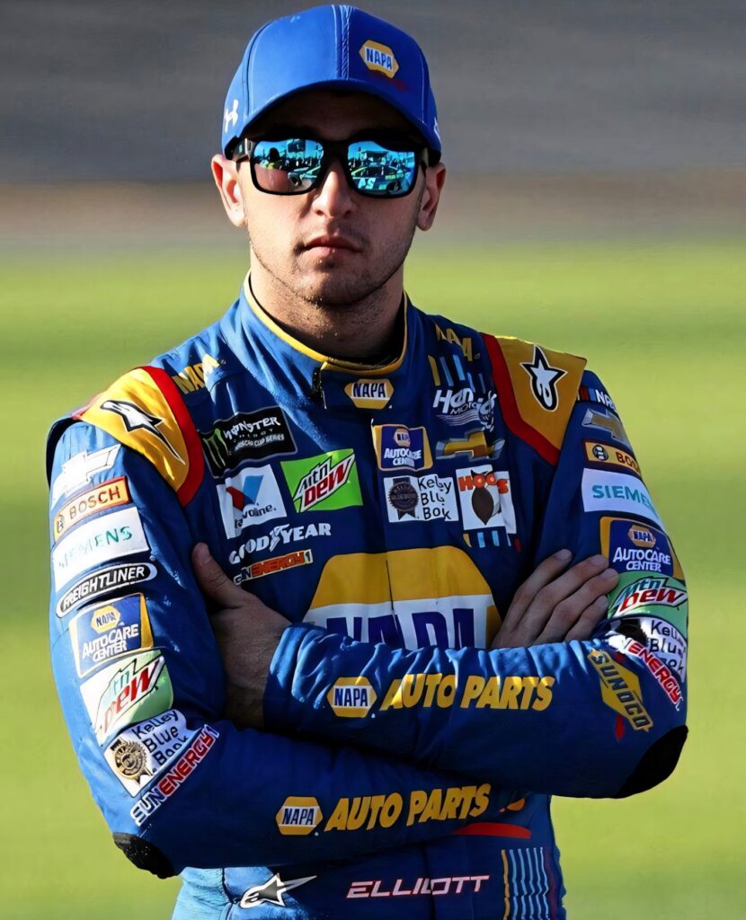 Chase Elliott in blue yellow NAPA racing suit with reflective sunglasses on blurred racetrack background Wallpaper