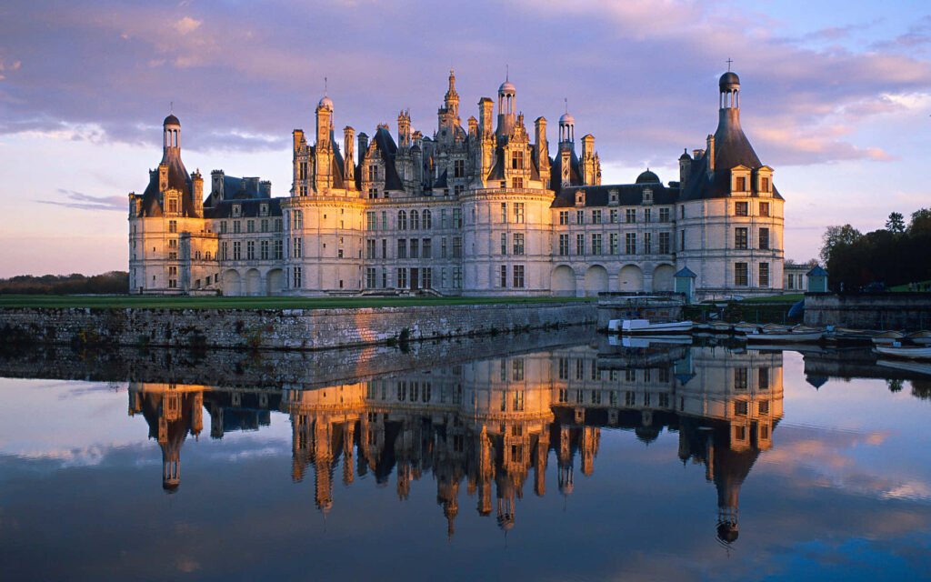 Château de Chambord French Renaissance castle reflecting in calm water under warm afternoon light Wallpaper