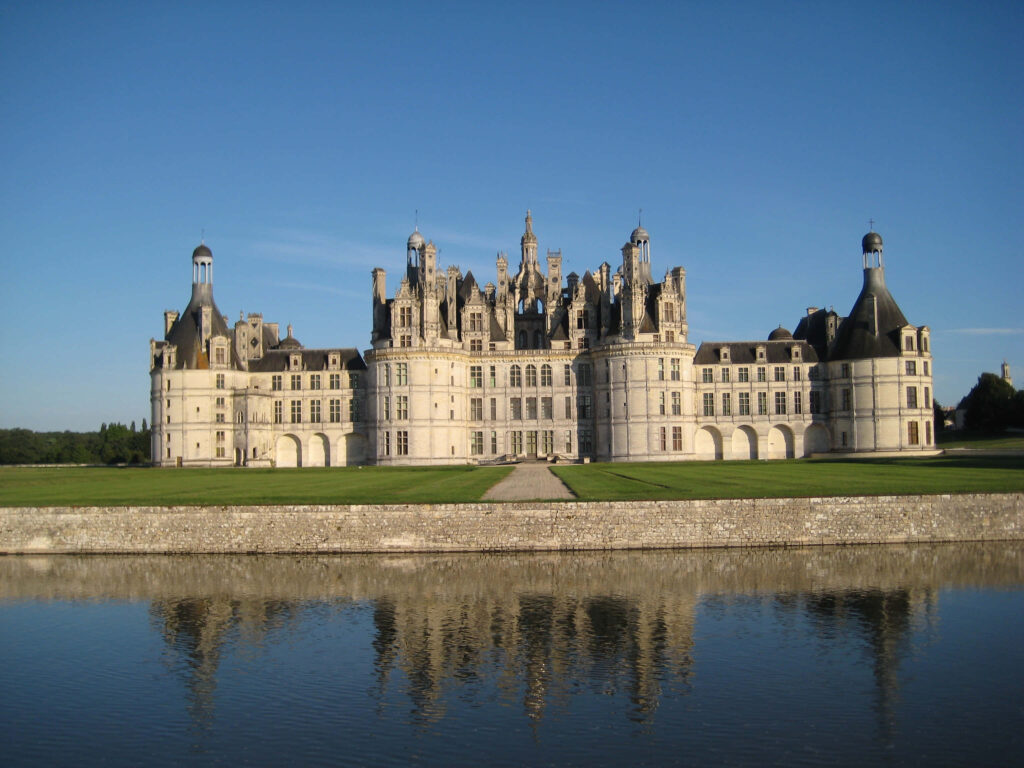 Majestic Château de Chambord Renaissance castle in Loire Valley mirrored in calm waters daylight Wallpaper