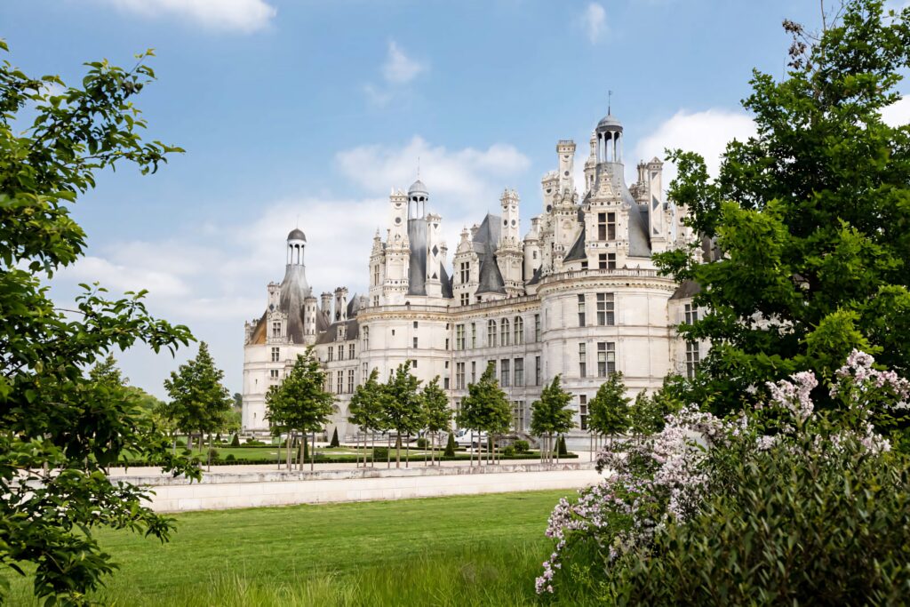 Château de Chambord Renaissance castle in Loire Valley with blue sky green lawns and flowers wallpaper