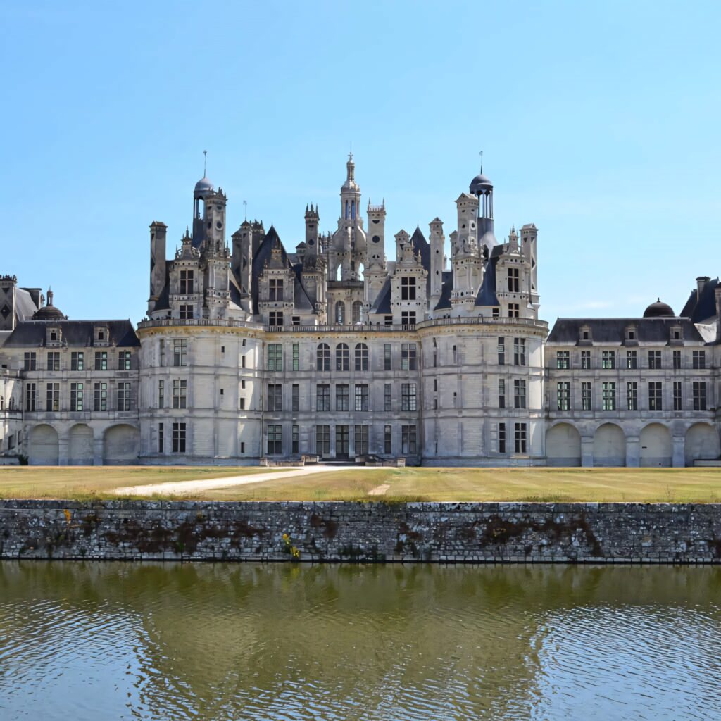 Majestic Château de Chambord Renaissance architecture with towers reflected in calm water background Wallpaper
