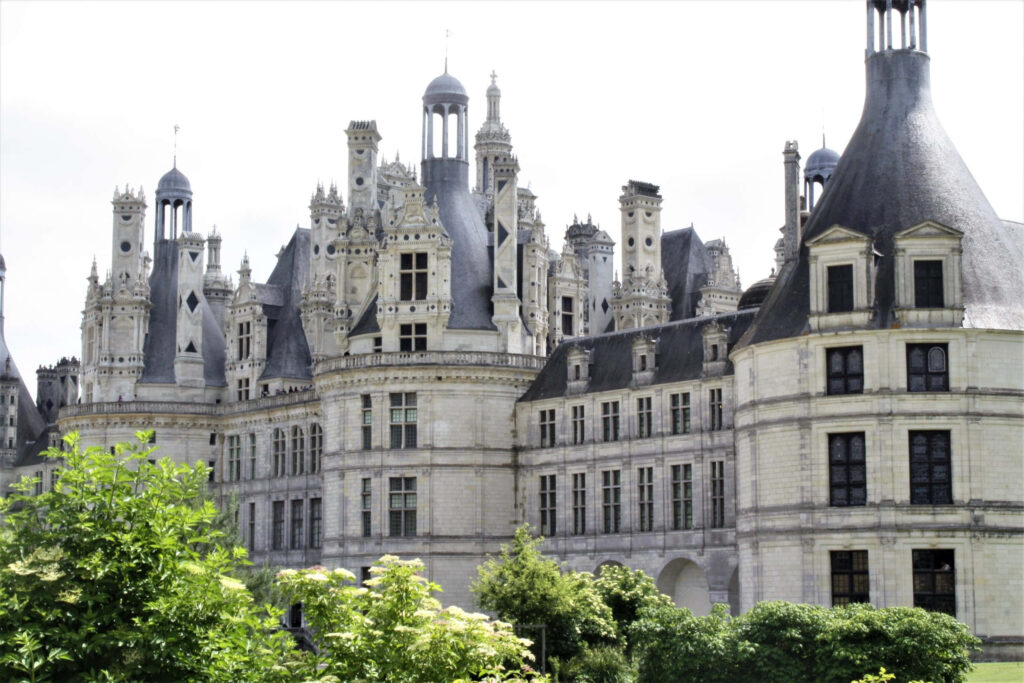 Château de Chambord grand Renaissance castle with turrets lush greenery bright sky wallpaper background