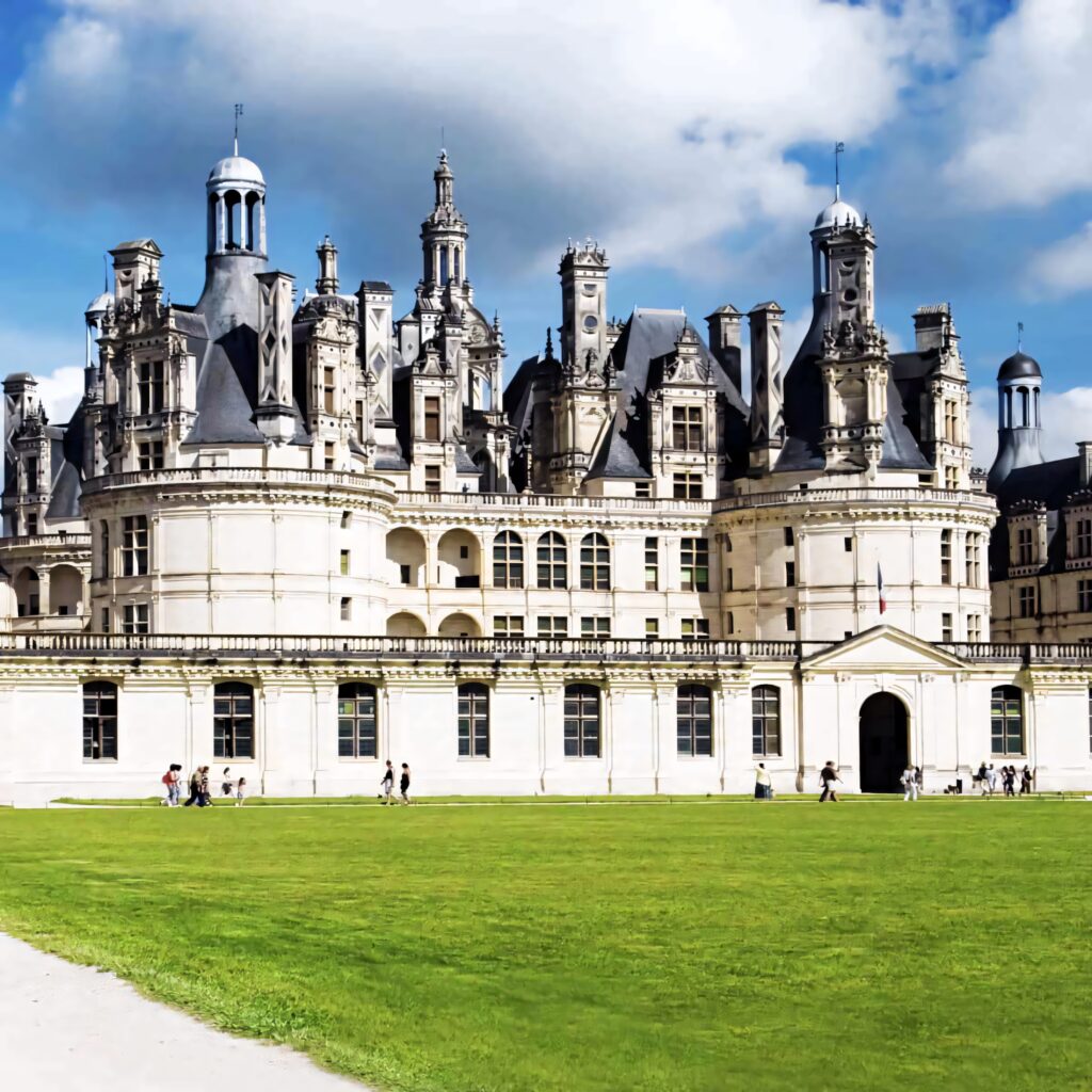 Château de Chambord Renaissance castle with intricate rooftops towers lush green lawns visitors France Wallpaper