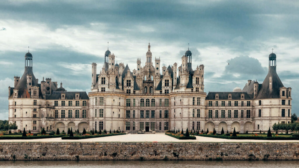 Château de Chambord Renaissance castle with grand towers and dramatic cloudy sky wallpaper background