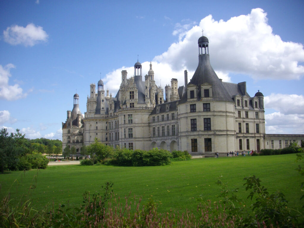 Château de Chambord Renaissance castle with ornate towers under blue sky and lush green lawn wallpaper
