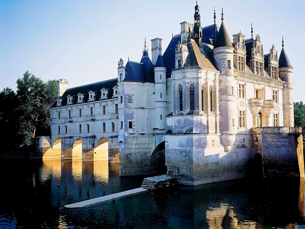 Chateau de Chenonceau Renaissance castle over river with arches in warm afternoon sunlight wallpaper