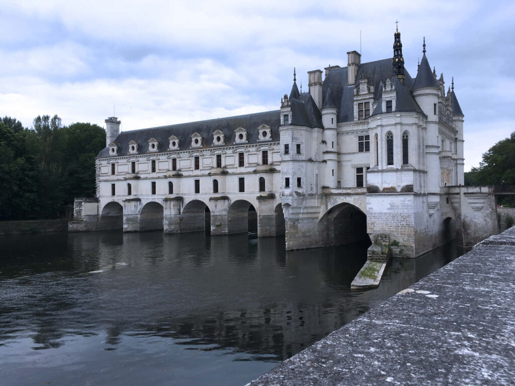 Château de Chenonceau Renaissance castle over reflective river under moody sky wallpaper background