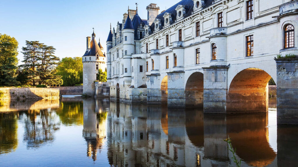 Château de Chenonceau at sunset with golden light reflecting Renaissance architecture over river Wallpaper