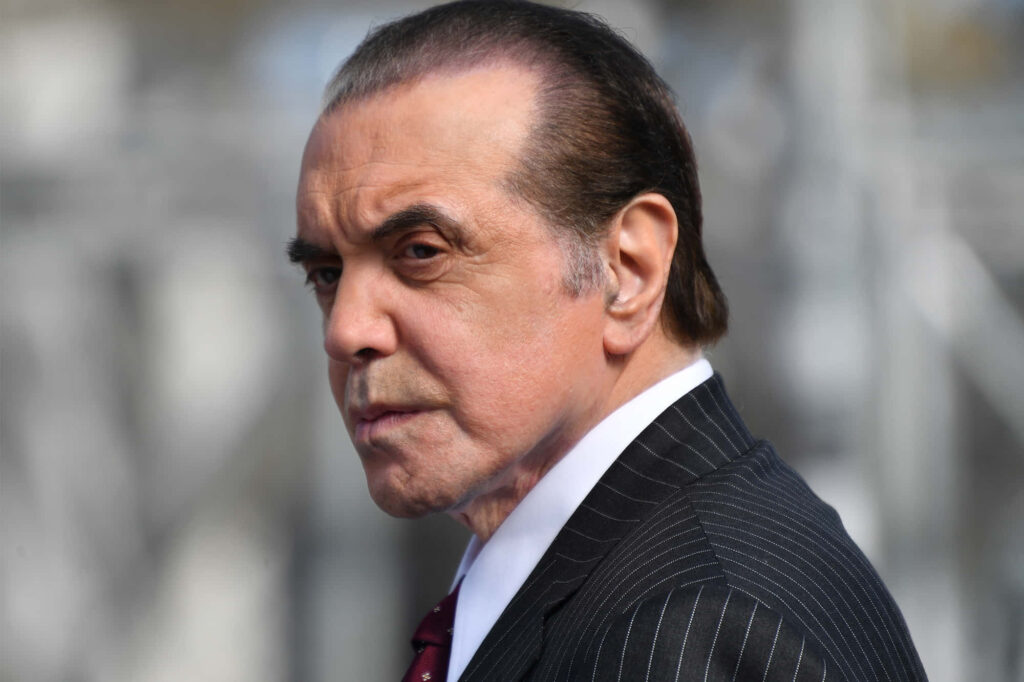 Chazz Palminteri in pinstripe suit intense contemplative pose dramatic professional wallpaper background